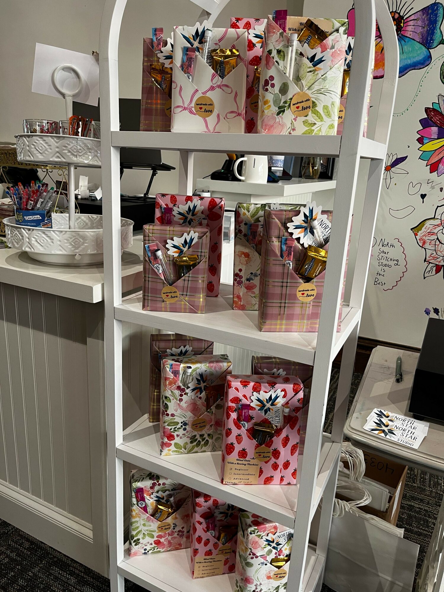 Bathroom shelf with decorative gift bags, toiletries, and a sink in the background.