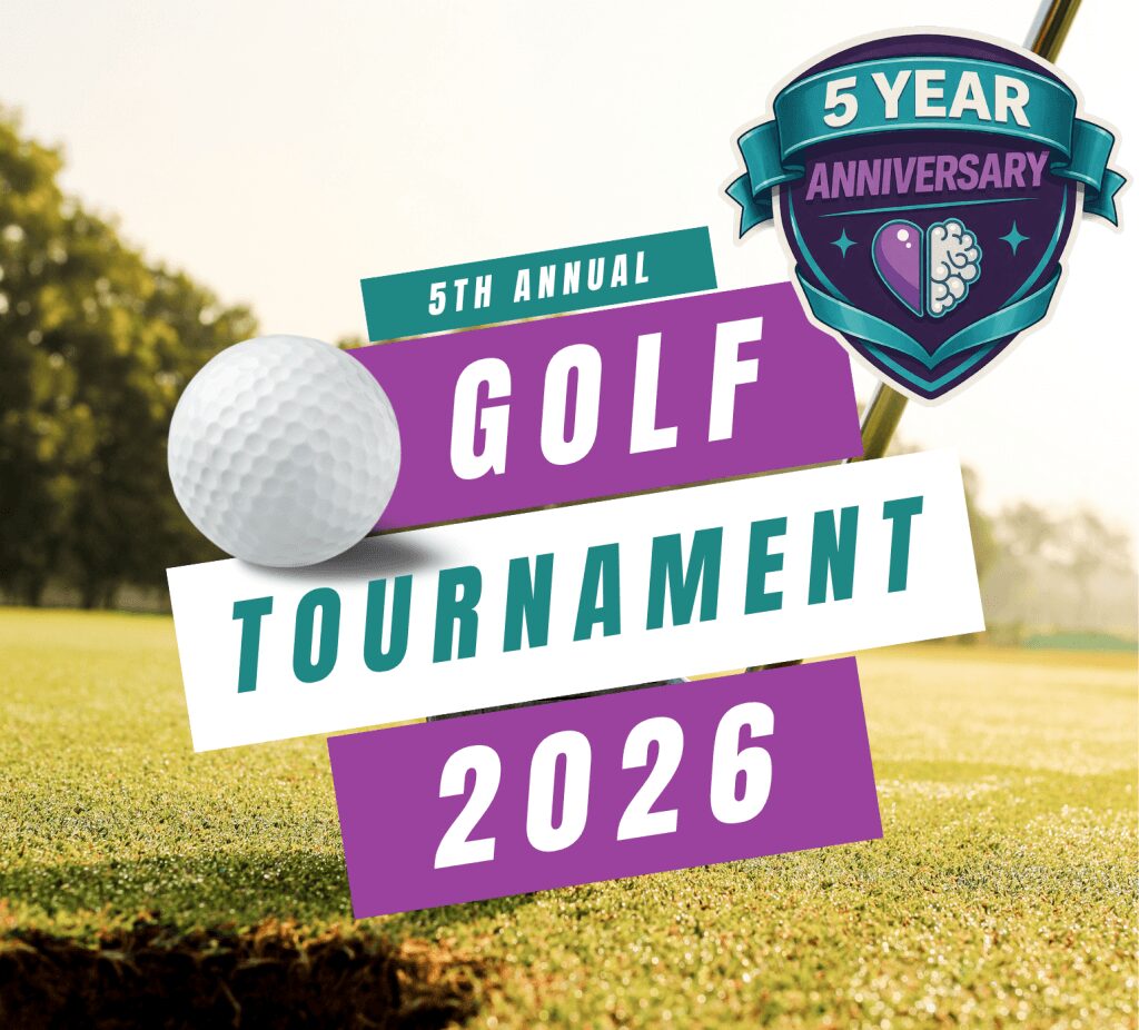 Golf tournament sign with a golf ball, celebrating 5 years, on a grassy field with trees in the background.