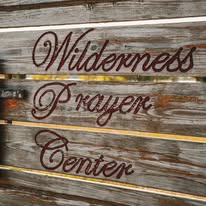 Wooden sign with the words 'Wilderness Parkway Center' in cursive script.