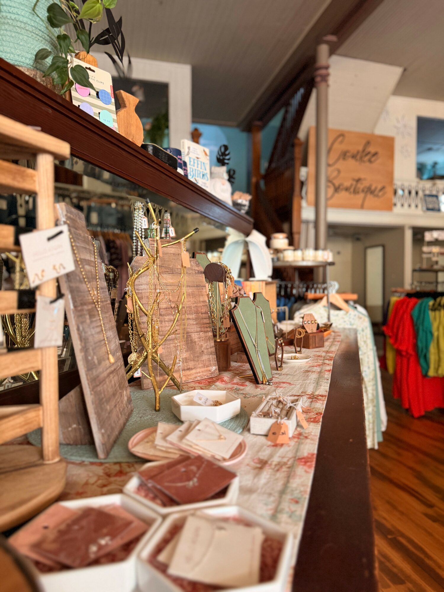 Display of various decorative items and picture frames on a table in a shop interior.