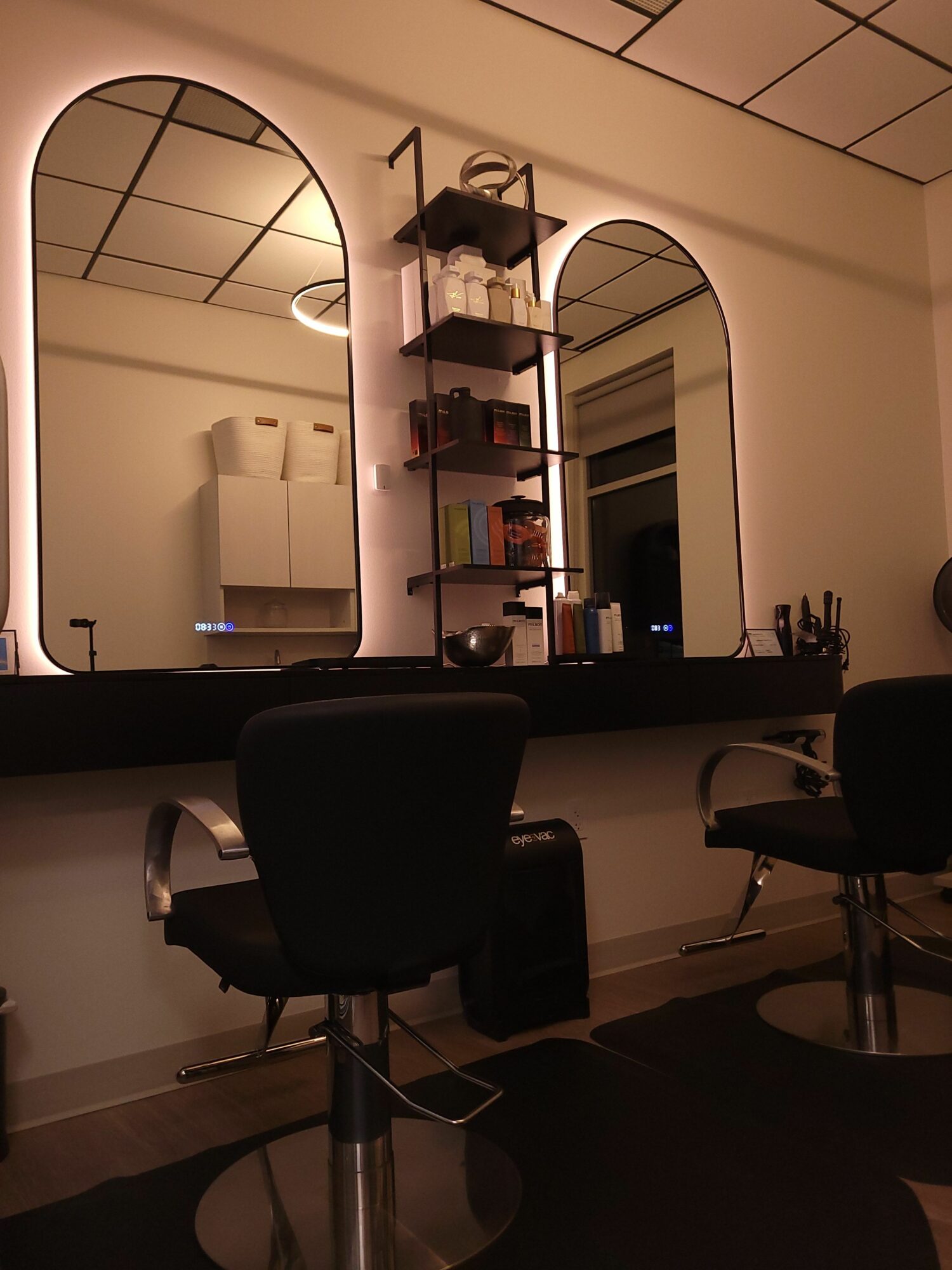 Office workspace with a desk, chair, computer, and shelves, viewed from the side. The image is rotated 90 degrees clockwise.
