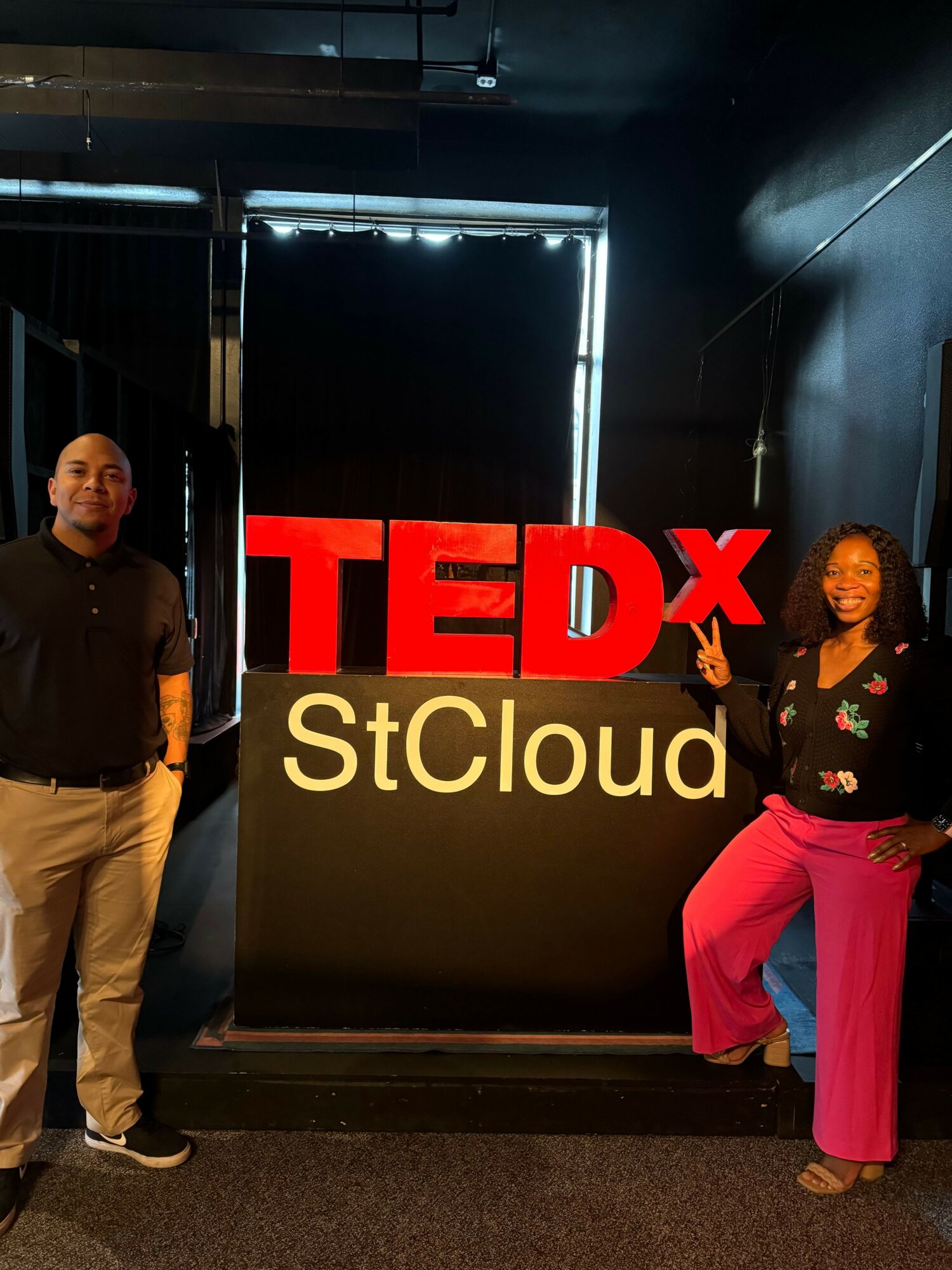 Person standing next to a sign that reads 'STUDIOX Cloud' with a black background.