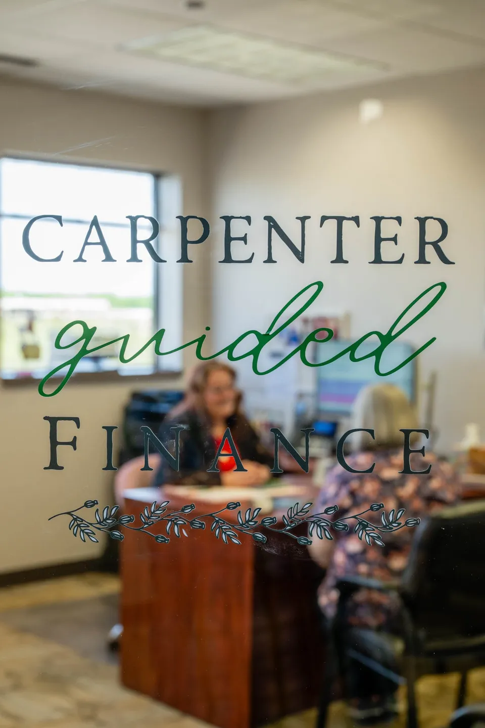 People sitting at a table in a room with a window, with text overlay reading 'Carpenter guided finance'.