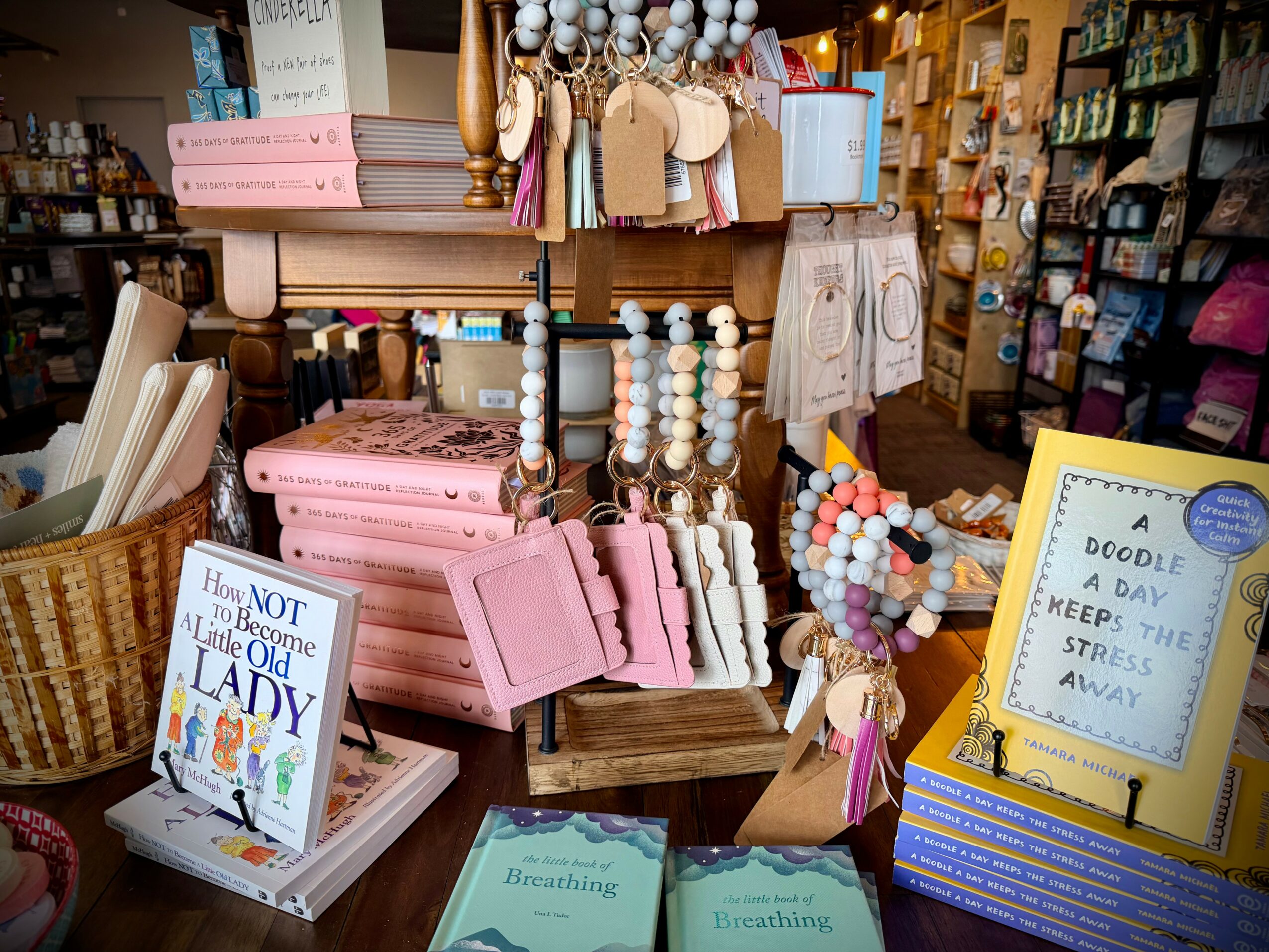 Display of books, jewelry, and decorative items in a store, with shelves and signs visible in the background.