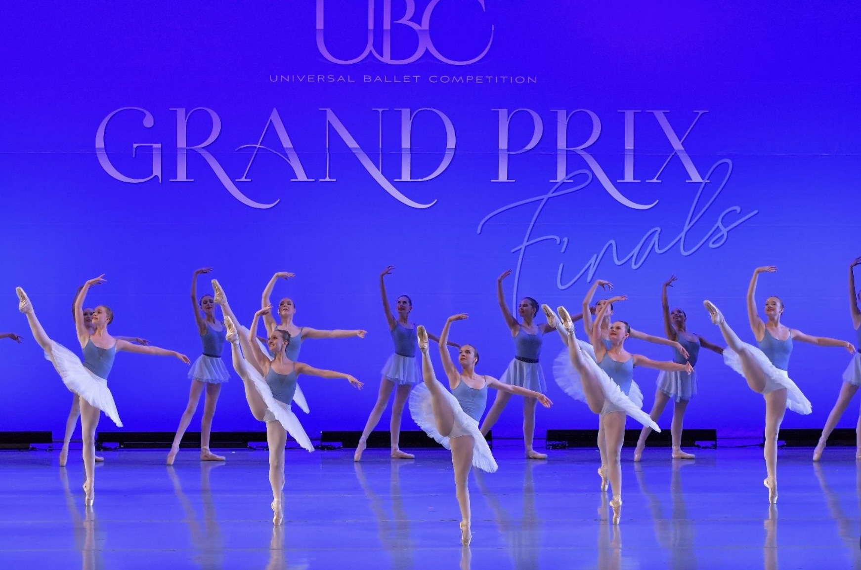 Ballet dancers perform on stage with a blue background and text reading 'Grand Prix Finals'.