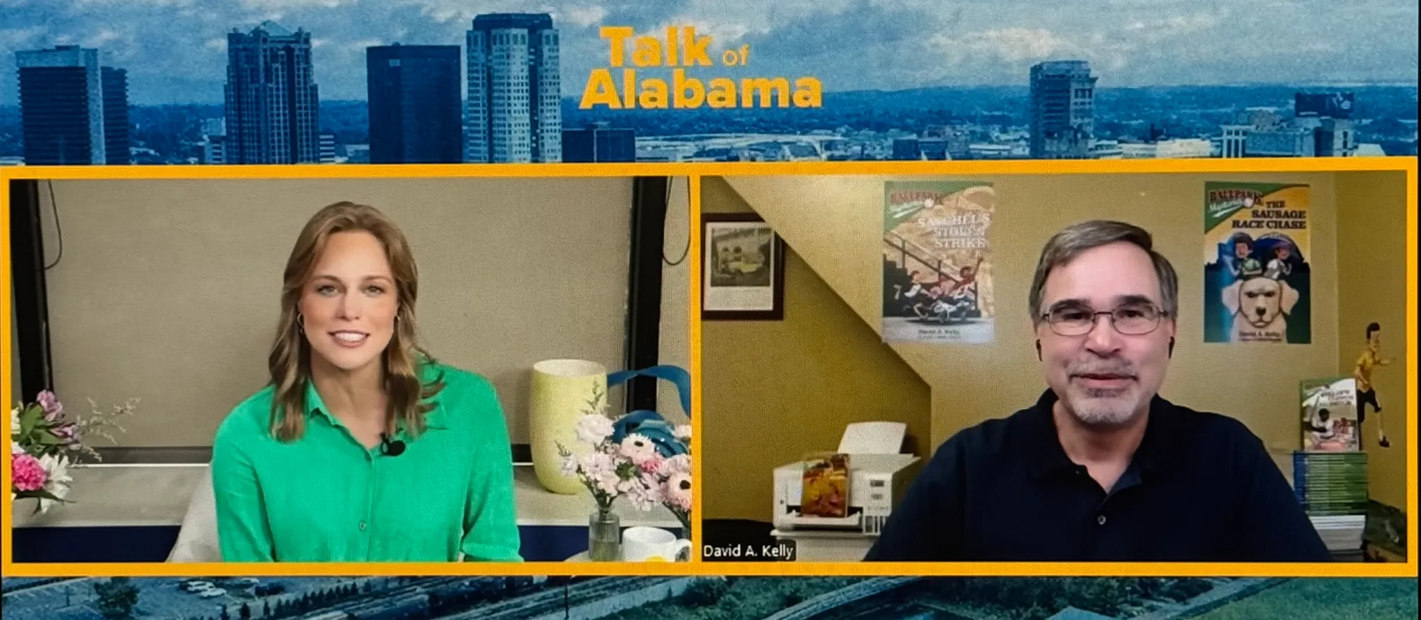 Two people in a video call, woman on the left with a green top, man on the right with glasses and a black shirt, background of a room and city skyline.