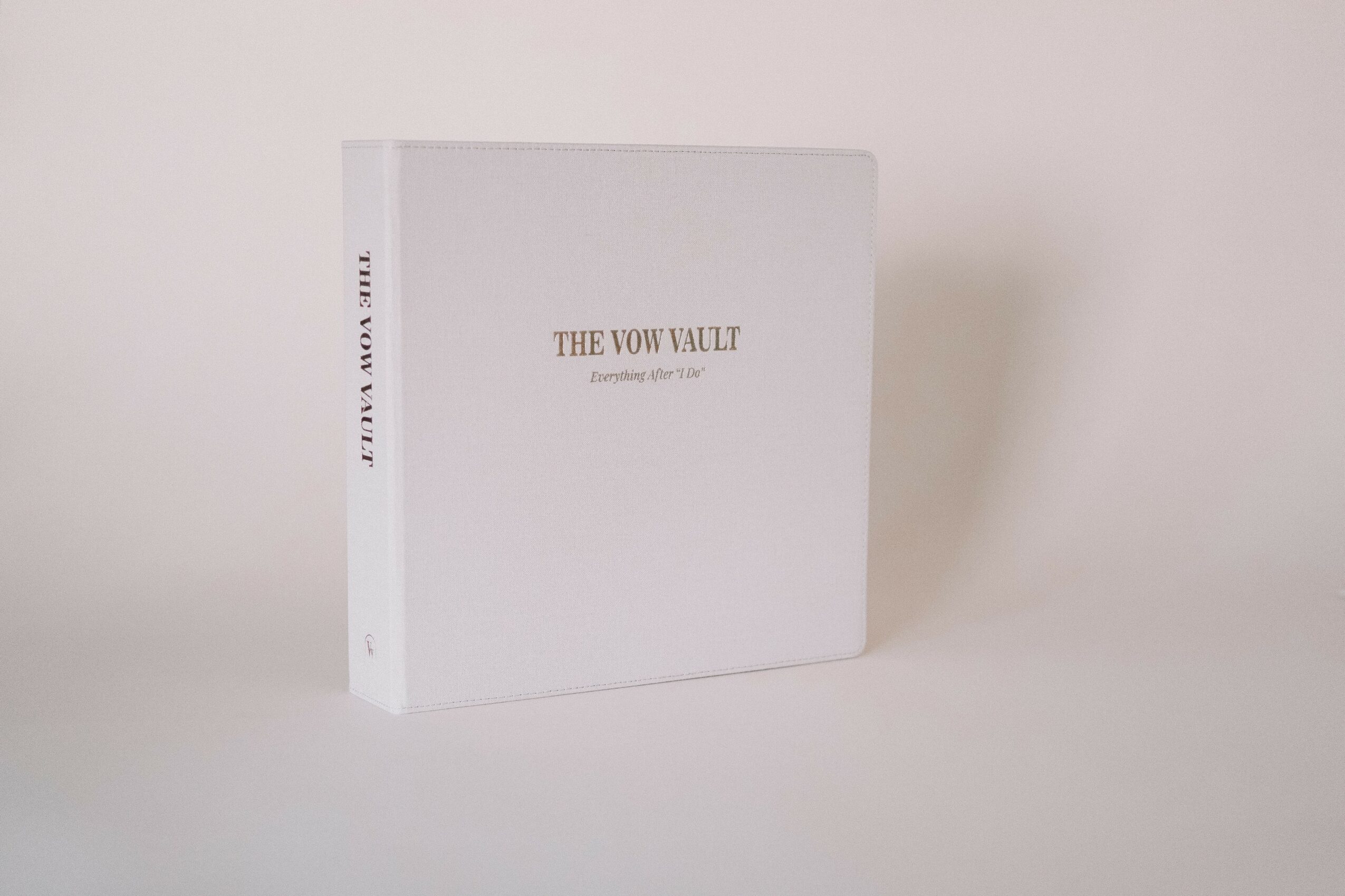 White book titled 'The Vow Vault' standing upright on a plain white surface with a plain white background.