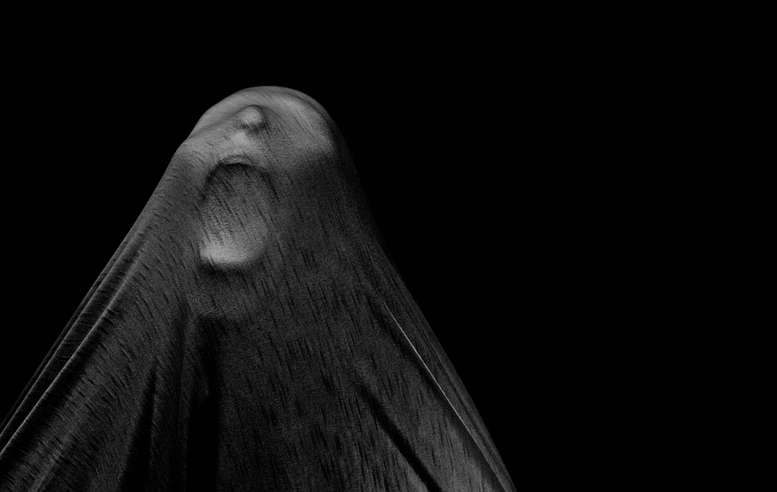 Close-up of a water droplet on a textured surface, with a dark background.
