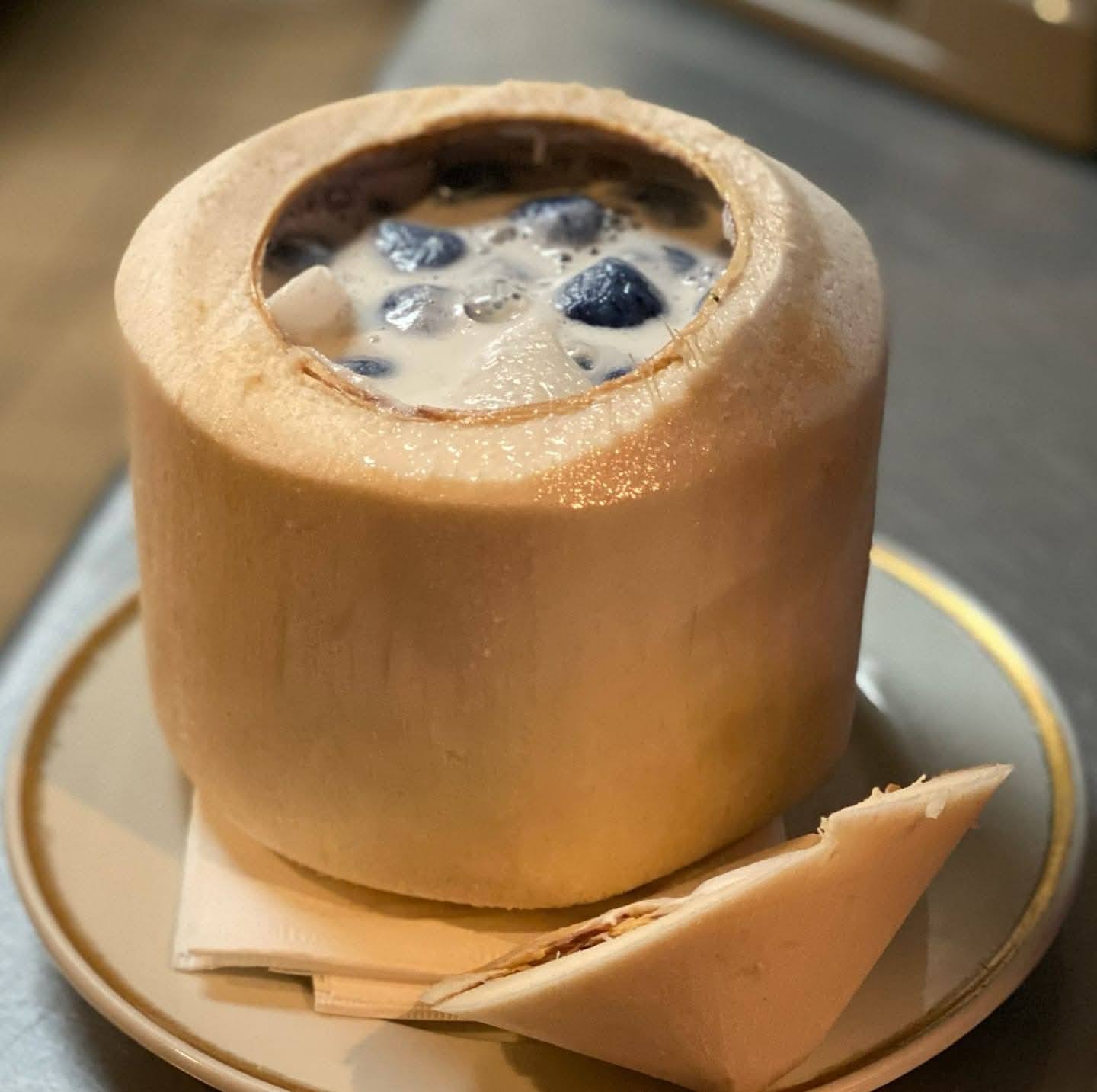 A hollowed-out apple filled with blueberries and cream, served on a plate with a piece of cheese or bread.