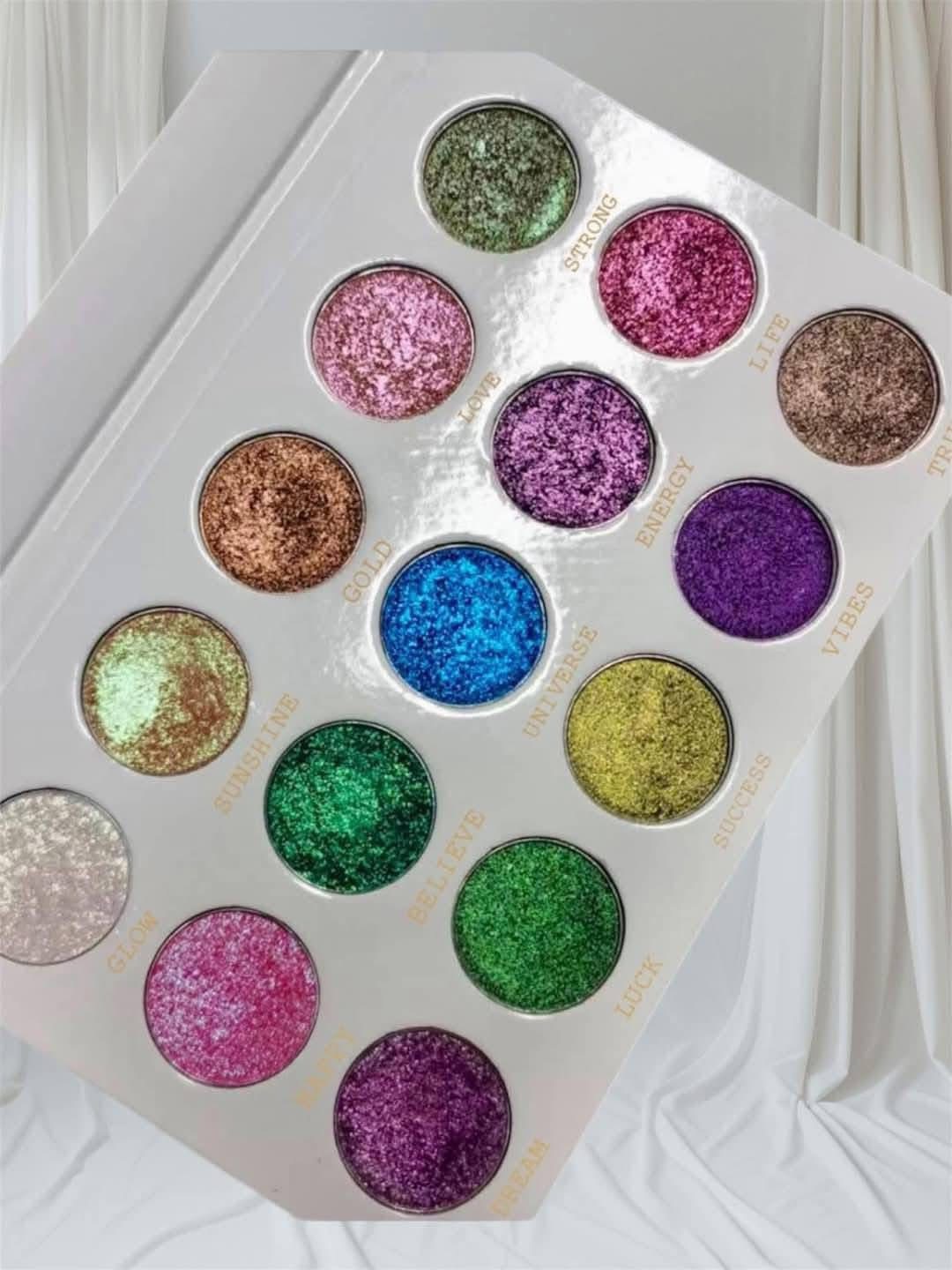 Palette with 16 colorful glitter eyeshadows arranged in a grid, with a white background and curtains. Word count: 20.