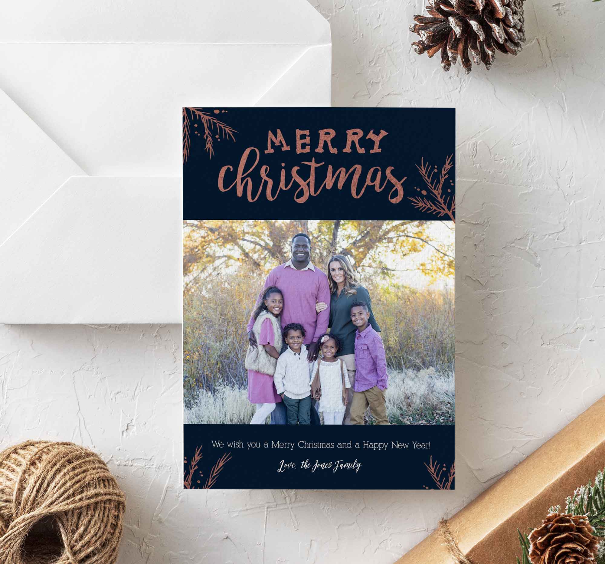 Family outdoors with trees, holiday greeting card with 'Merry Christmas' and a message below, on a white surface.