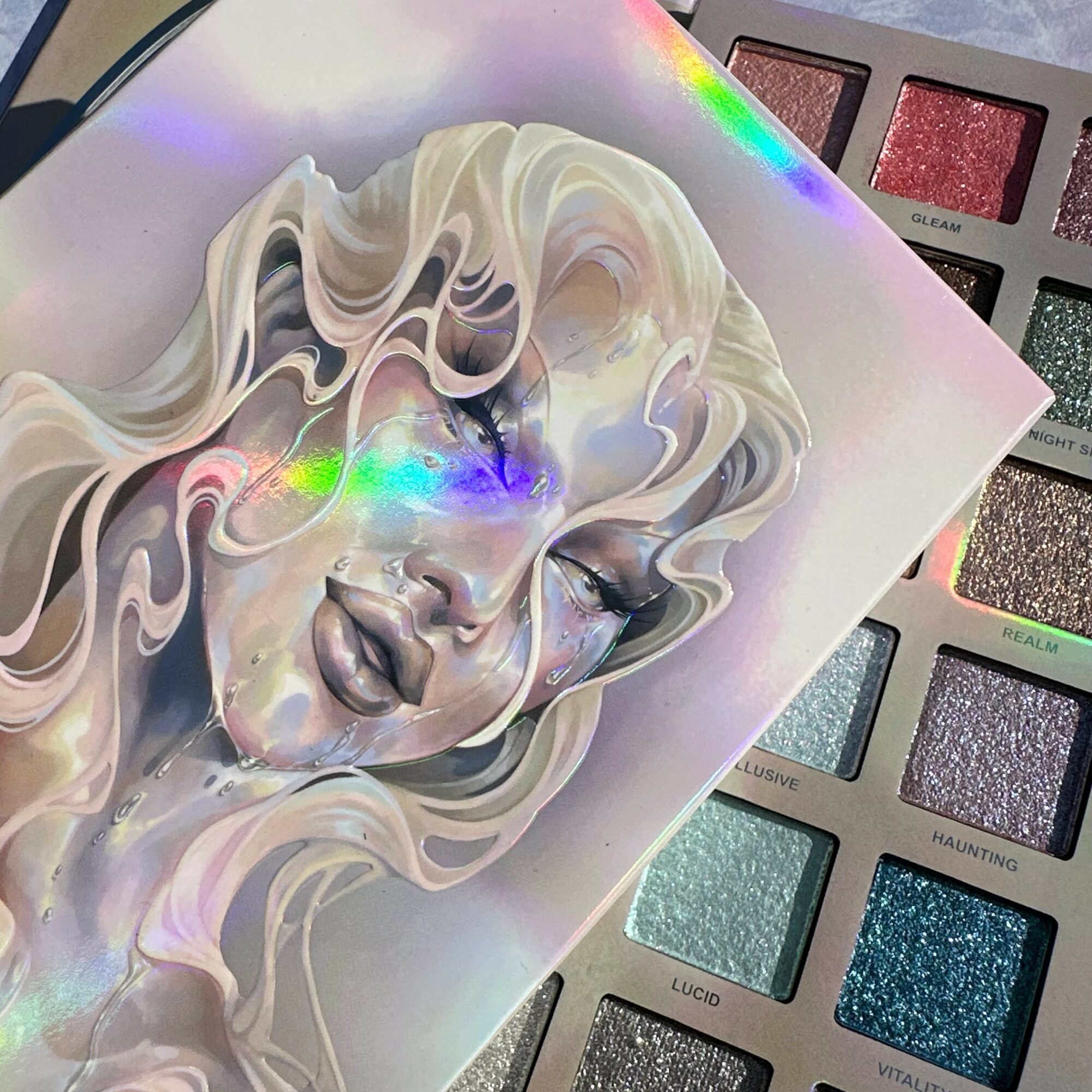 Illustration of a woman with flowing hair and closed eyes, with a holographic effect on her face.