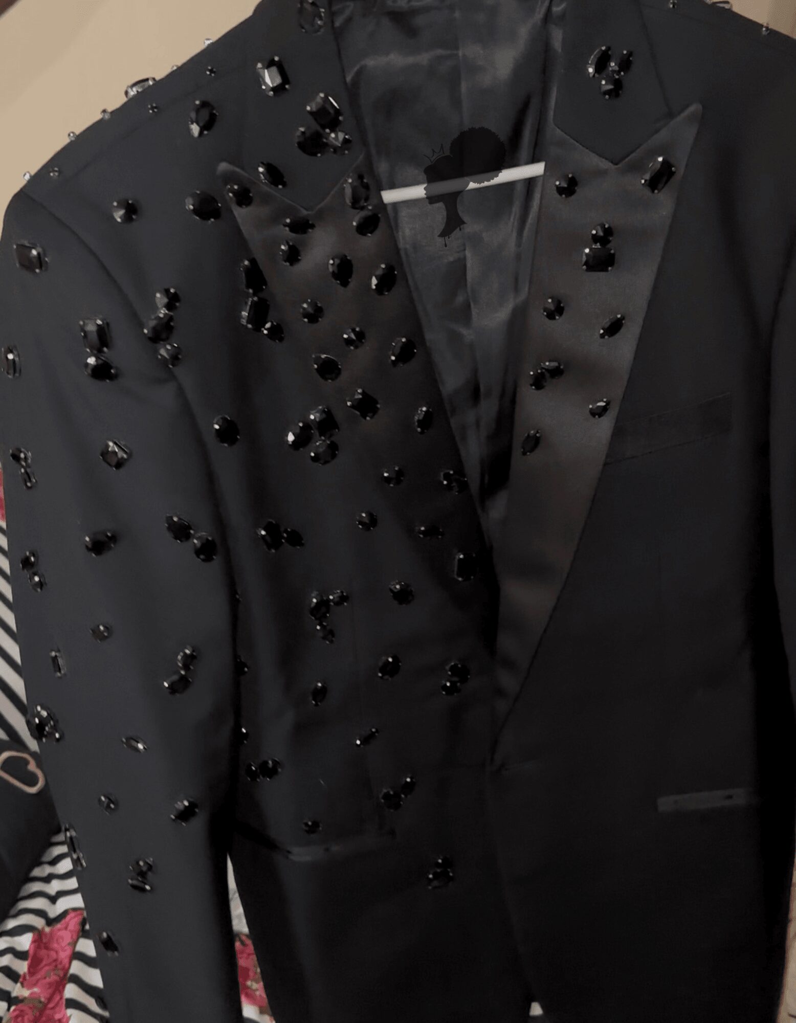 Black blazer with decorative black beads on the shoulder and lapel, tailored fit, with a satin lapel detail.
