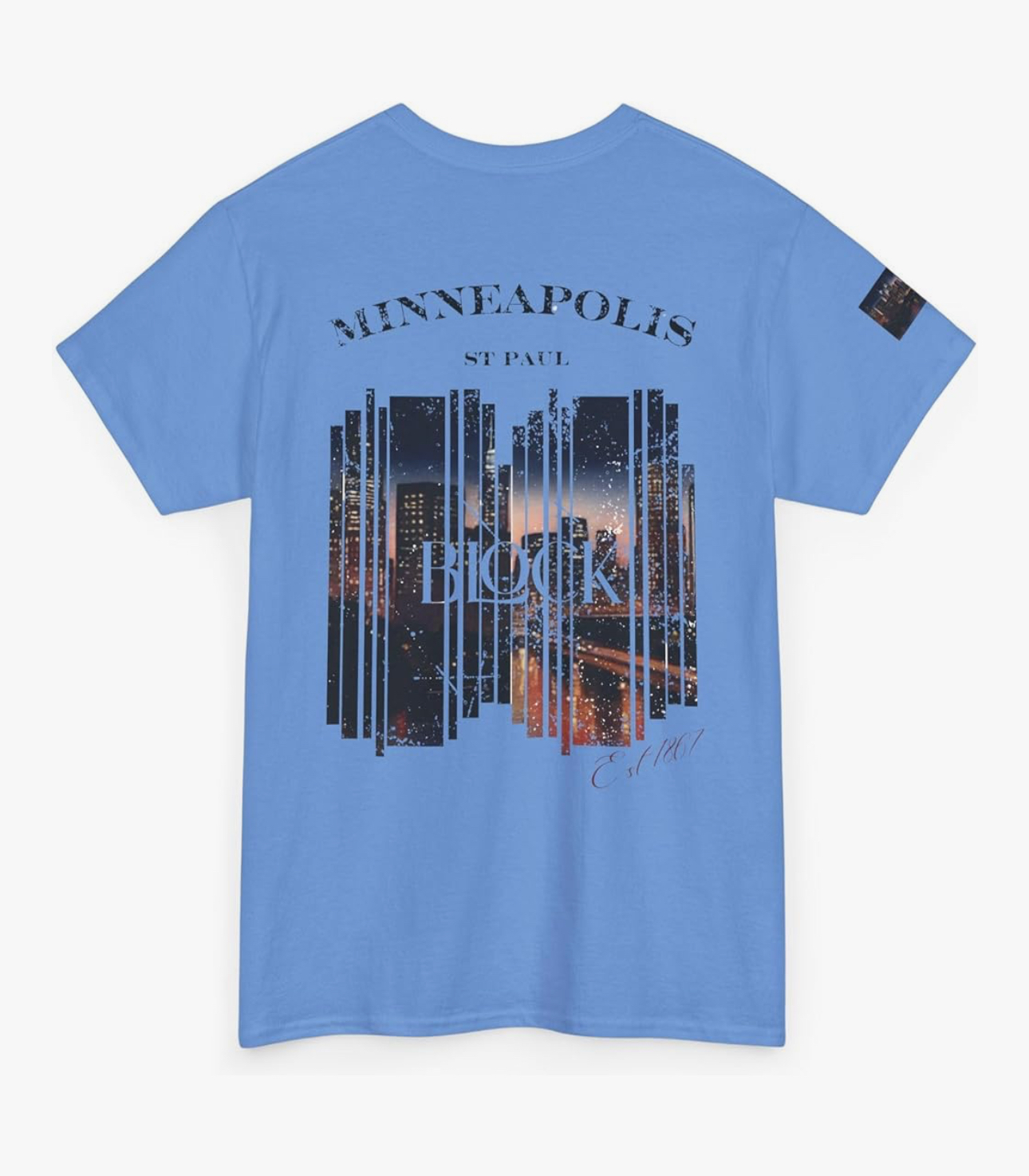 Blue T-shirt with cityscape and sunset graphic, text 'Minneapolis' and 'St. Paul', and a small patch on sleeve.