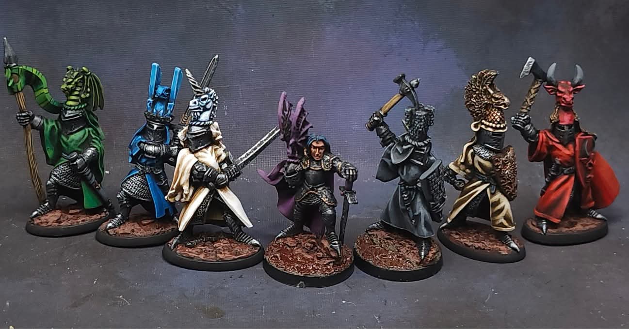 Seven painted miniature figures in fantasy armor and weapons, standing on round bases, against a dark background.