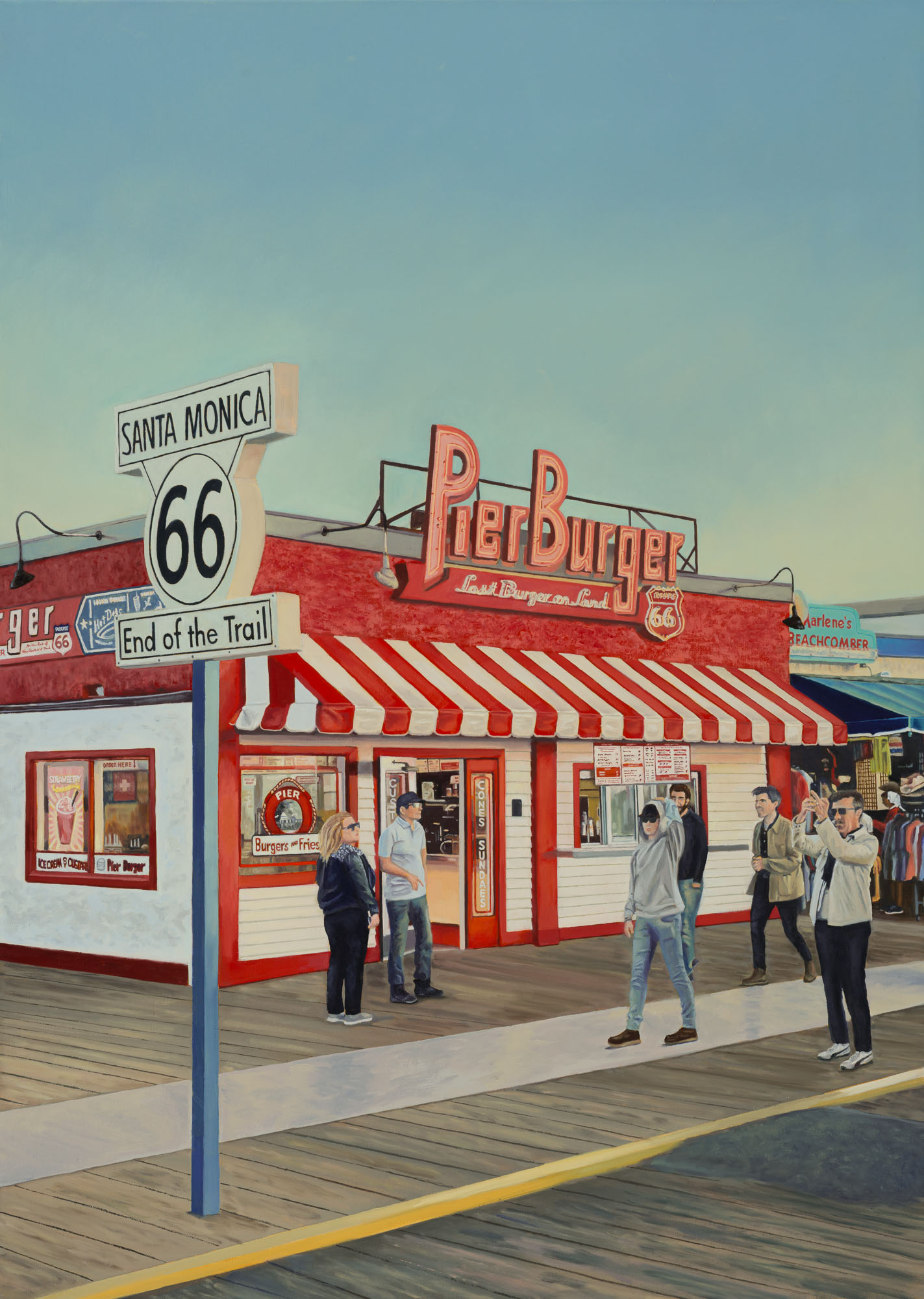People standing outside a burger restaurant with a red and white striped awning, on a boardwalk near Santa Monica, California.