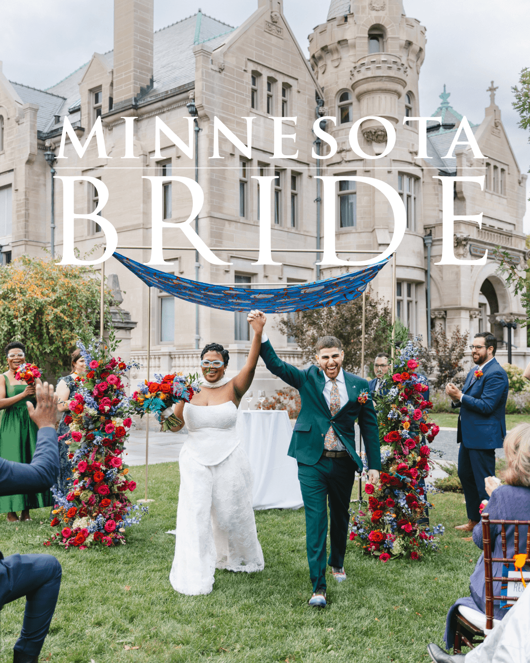 Bride and groom holding hands in front of a castle, surrounded by guests and floral arrangements, outdoors during daytime.