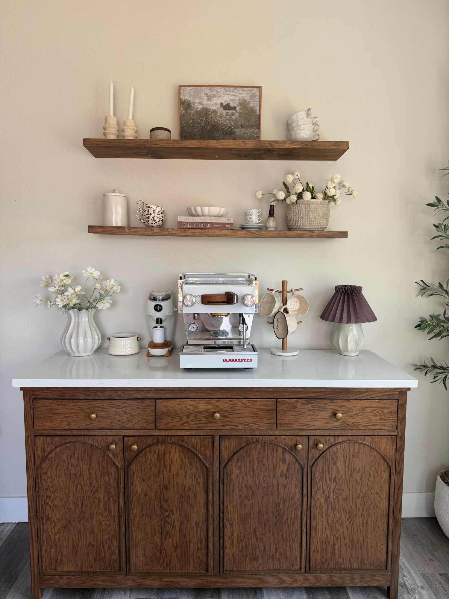 Wooden cabinet with three doors, white shelf with decorative items, and wall shelves with vases and ornaments.