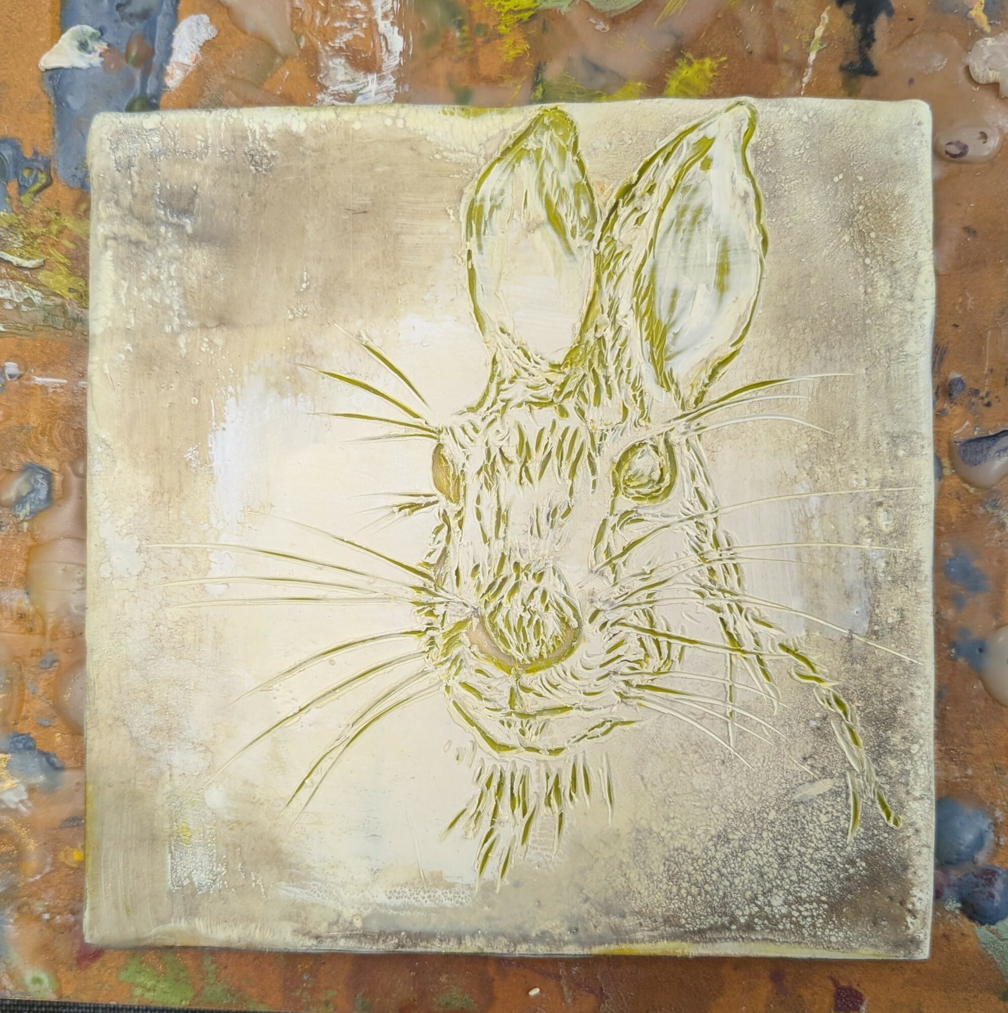 Line drawing of a rabbit's face on a textured background, with large ears and detailed whiskers.