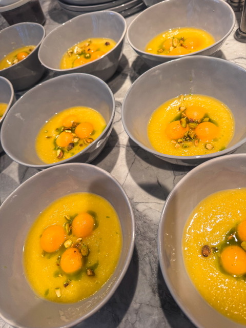 Six bowls with raw eggs, herbs, and spices on a kitchen counter.