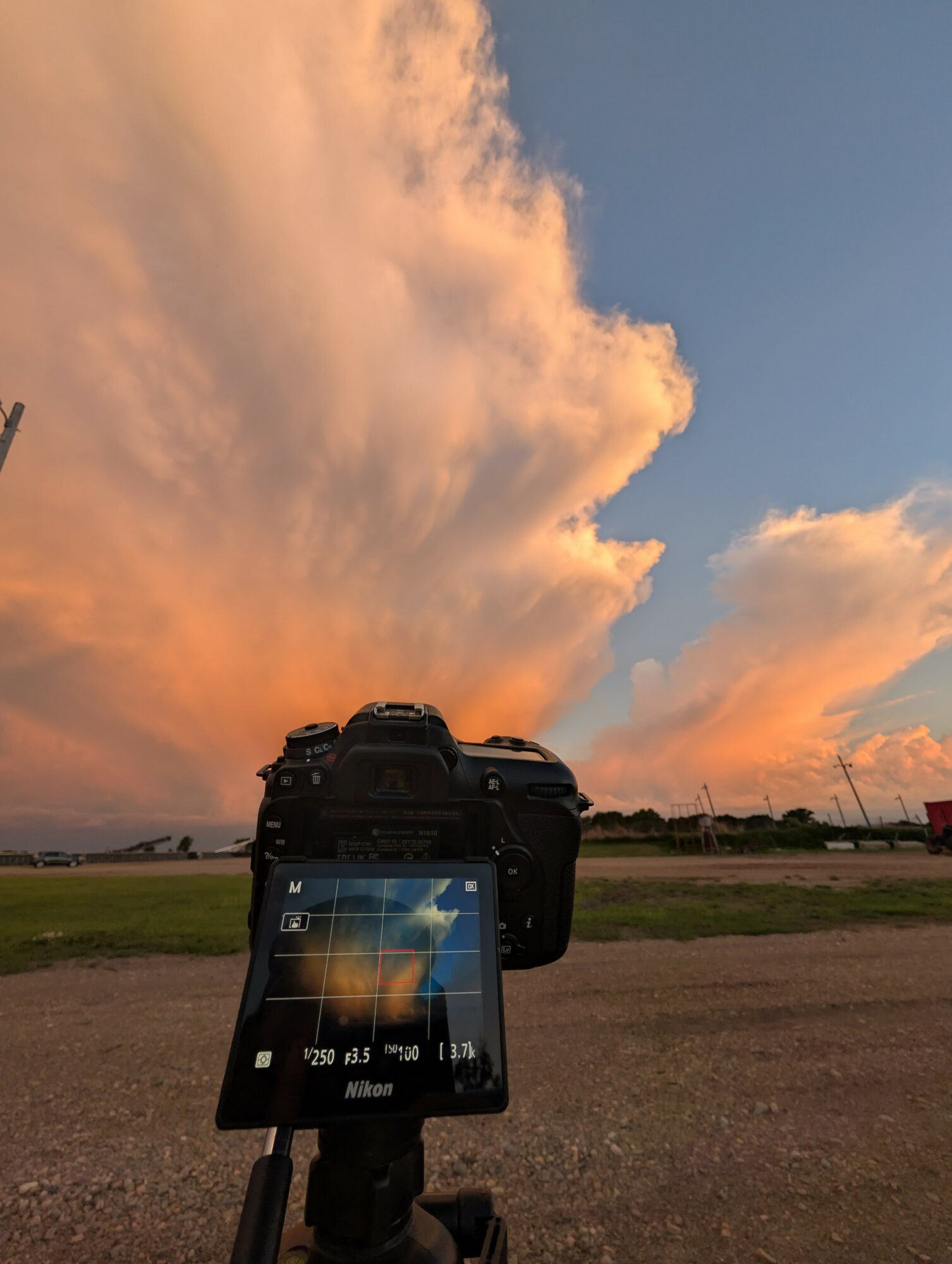 Camera on ground captures sky with large, colorful clouds during sunset or sunrise.