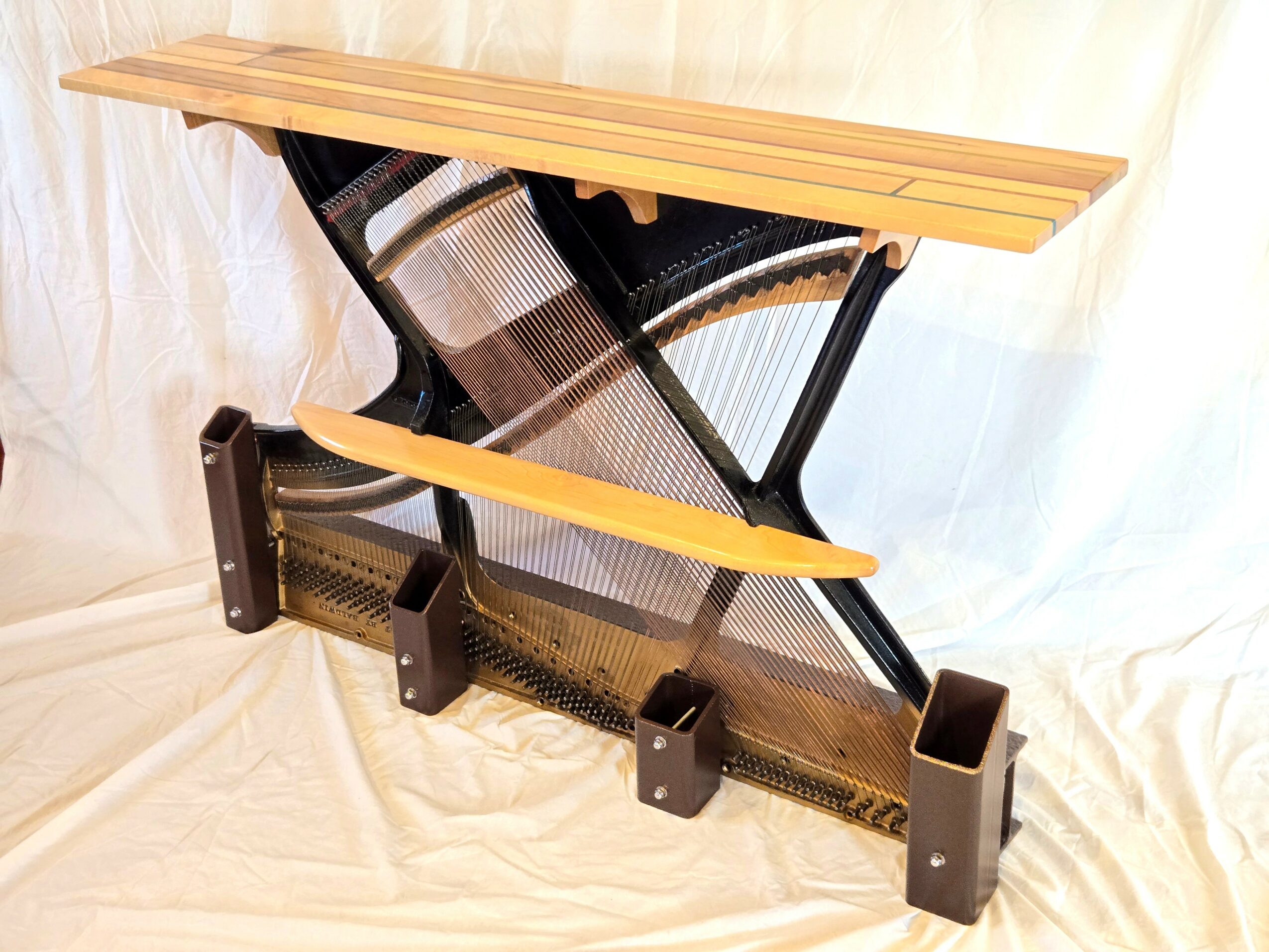 A black and wooden adjustable standing desk converter with a wooden top, set on a white fabric background.